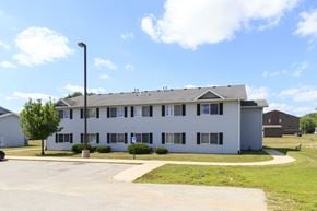 Forest City apartment for rent - A white building with a grey roof and a parking lot in front.