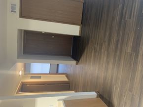 Washington apartment for rent - A wooden cabinet with a black object on top is mounted on a wall with wood paneling.