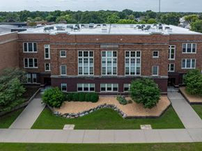Spencer apartment for rent - A red brick building with a landscaped front yard.