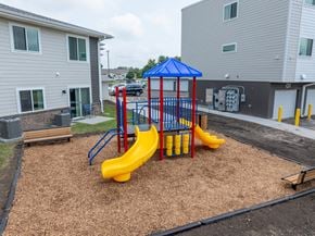 Spirit Lake apartment for rent - A playground with a blue and yellow slide in the foreground.