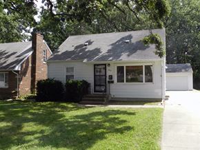 Cedar Rapids apartment for rent - A white house with a black door and a brick chimney.