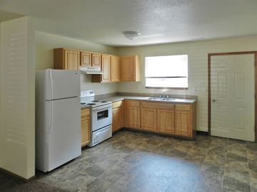 Cedar Rapids apartment for rent - a kitchen with white appliances and wooden cabinets