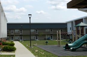 Cedar Rapids apartment for rent - A playground with a green slide in front of a building.
