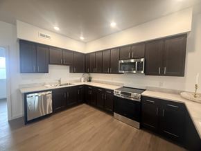 Hawarden apartment for rent - A modern kitchen with dark brown cabinets and stainless steel appliances.