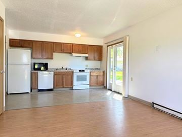 Adel apartment for rent - A kitchen with wooden cabinets and white appliances.