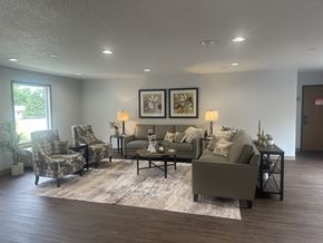 Adel apartment for rent - A living room with a grey couch, two chairs, a coffee table, and two framed pictures on the wall.
