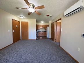 Forest City apartment for rent - an empty living room with a ceiling fan and a kitchen in the background
