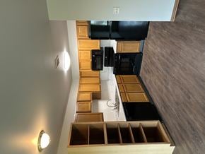 Spirit Lake apartment for rent - A kitchen with wooden drawers and a black fridge.