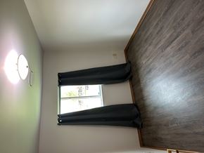 Spirit Lake apartment for rent - A window with black blinds in a room with a wooden wall.