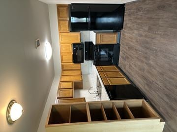 Spirit Lake apartment for rent - A modern kitchen with wooden drawers and black appliances.