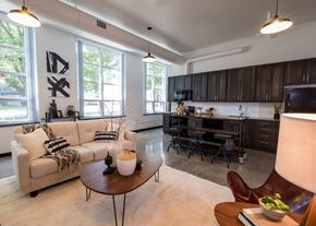 West Des Moines apartment for rent - A modern living room with a couch, coffee table, and a kitchen area in the background.