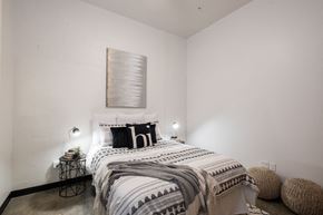 West Des Moines apartment for rent - A bedroom with a bed, a lamp, and a wall hanging.