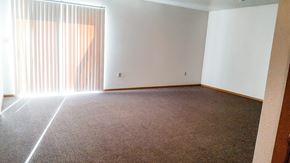 Hawarden apartment for rent - A room with a carpeted floor and a large window with blinds.