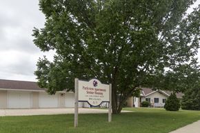 Sibley apartment for rent - A sign for Parkview Apartments Senior Housing stands in front of a building.