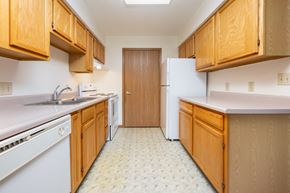 Lake Park apartment for rent - A kitchen with wooden cabinets and a white fridge.