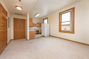 Spirit Lake apartment for rent - A kitchen area with a refrigerator, cabinets, and a window.