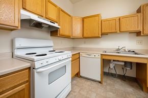 Spirit Lake apartment for rent - A kitchen with a white stove and wooden cabinets.