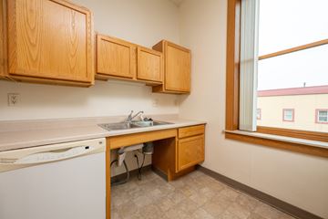 Spirit Lake apartment for rent - A kitchen with wooden cabinets and a washing machine.
