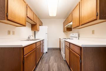 Spirit Lake apartment for rent - A kitchen with wooden cabinets and white appliances.