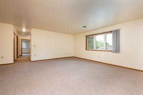 Spirit Lake apartment for rent - A large empty room with a window and a door.