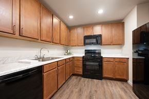 Spirit Lake apartment for rent - A kitchen with wooden cabinets and black appliances.