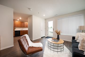 Spirit Lake apartment for rent - A living room with a brown leather chair and a white couch.