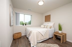 Spirit Lake apartment for rent - A bedroom with a bed, a small table, and a window.