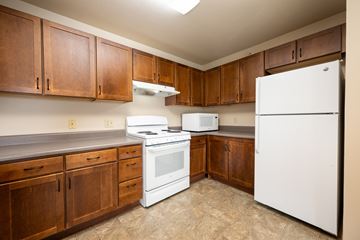 Milford apartment for rent - A kitchen with white appliances and wooden cabinets.