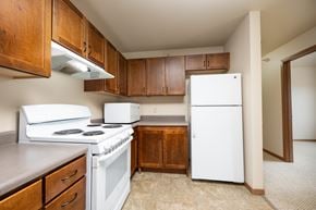 Milford apartment for rent - A kitchen with white appliances and wooden cabinets.