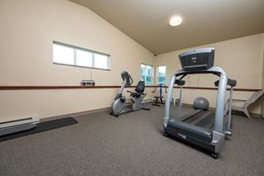 Milford apartment for rent - A home gym with a treadmill, exercise bike, and other equipment.