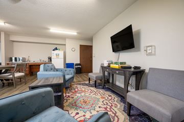 Spencer apartment for rent - A living room with a grey couch and a blue armchair.