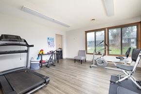 Spencer apartment for rent - A home gym with a treadmill, exercise bike, and other equipment.