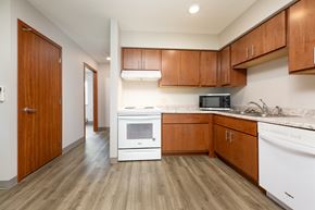 Spencer apartment for rent - A kitchen with wooden cabinets and white appliances.
