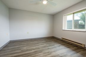 Spencer apartment for rent - A room with a ceiling fan and a window with a view of a building and a tree.