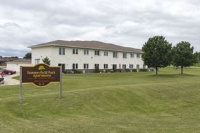 Spirit Lake apartment for rent - A sign for Summerfield Park Apartments stands in front of a white building.