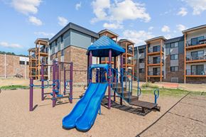 Plymouth apartment for rent - A playground with a blue slide and a purple structure.