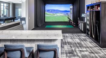 A living room with a bar and a view of a golf course