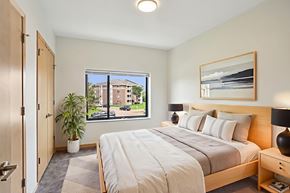 St Louis Park apartment for rent - A bedroom with a large bed and a window overlooking a street.