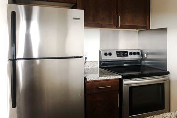 Richfield apartment for rent - A stainless steel refrigerator stands next to a stove in a kitchen.