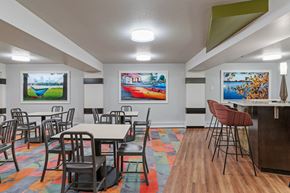 Minneapolis townhouse for rent - a dining room with tables and chairs and paintings on the wall at Axon Green, Minneapolis, MN, 55416