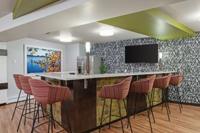 Minneapolis townhouse for rent - a kitchen with a bar with chairs and a television at Axon Green, Minneapolis, MN, 55416