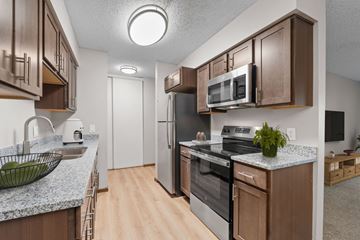 Plymouth apartment for rent - A kitchen with brown cabinets and a granite countertop.