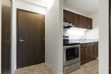 Robbinsdale apartment for rent - A kitchen with a stove top oven and brown cabinets.