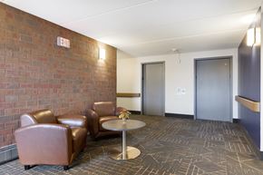 Robbinsdale apartment for rent - A room with a brick wall and a round table with chairs.
