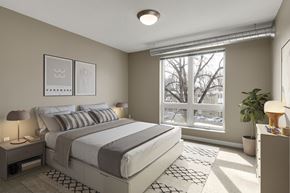 Minneapolis apartment for rent - a bedroom with a large window and a bed at Be @ Axon Green, Minnesota, 55416