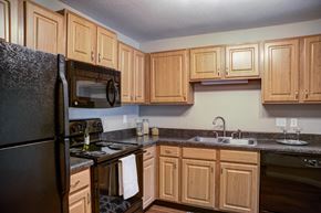 St Louis Park apartment for rent - a kitchen with black appliances and wooden cabinets at Cityscape, St Louis Park, 55416