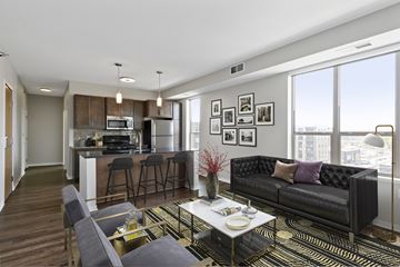 Minneapolis apartment for rent - A modern living room with a black couch and a coffee table.