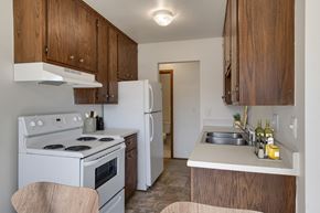 Roseville apartment for rent - a kitchen with white appliances and wooden cabinets at Hamline Terrace, Roseville, MN, 55113