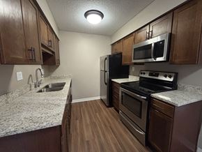 Plymouth apartment for rent - A kitchen with wooden cabinets and granite countertops.