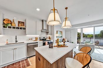 A modern kitchen with a large island and chairs.